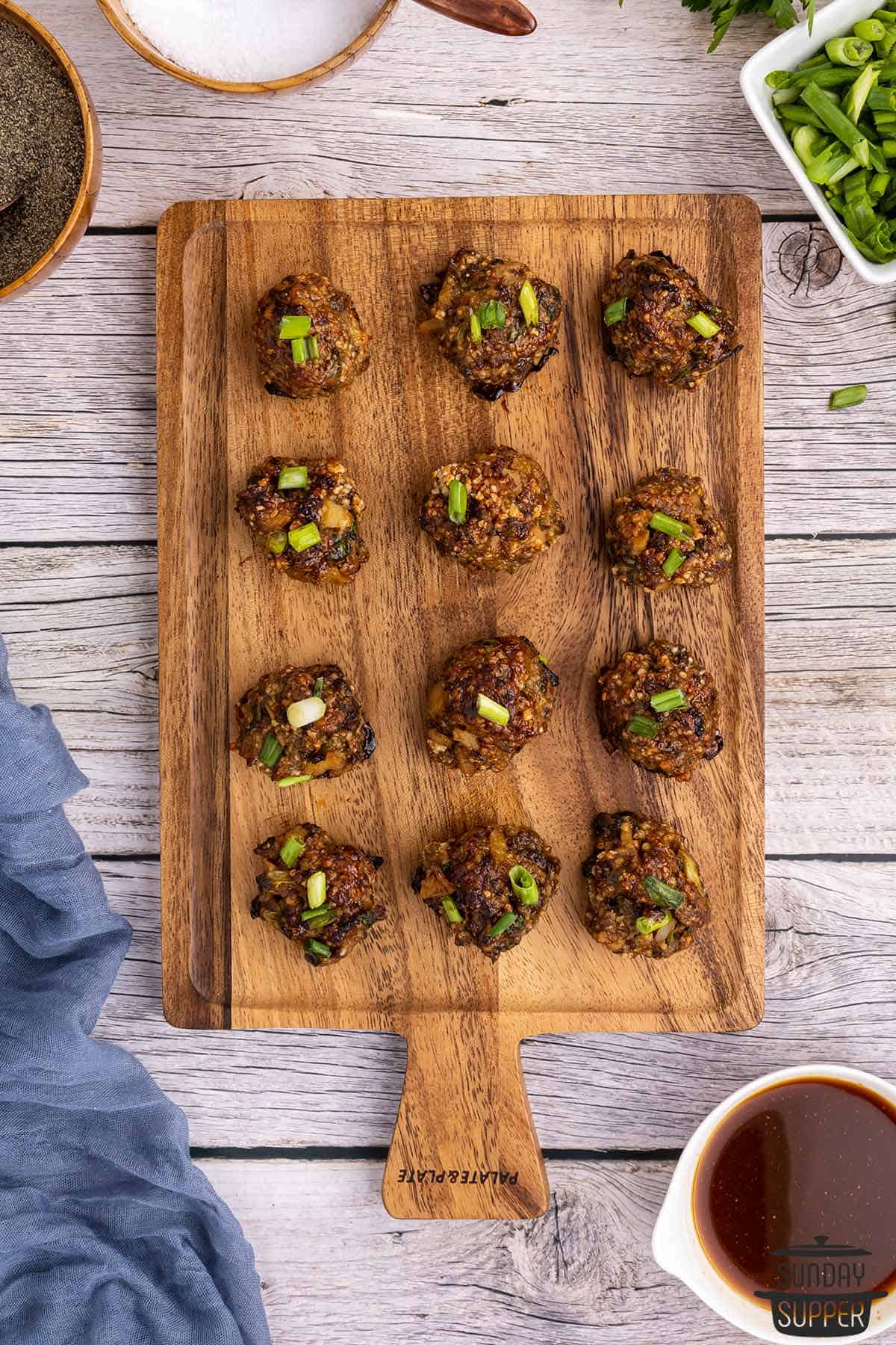 a serving board filled with hoisin meatballs