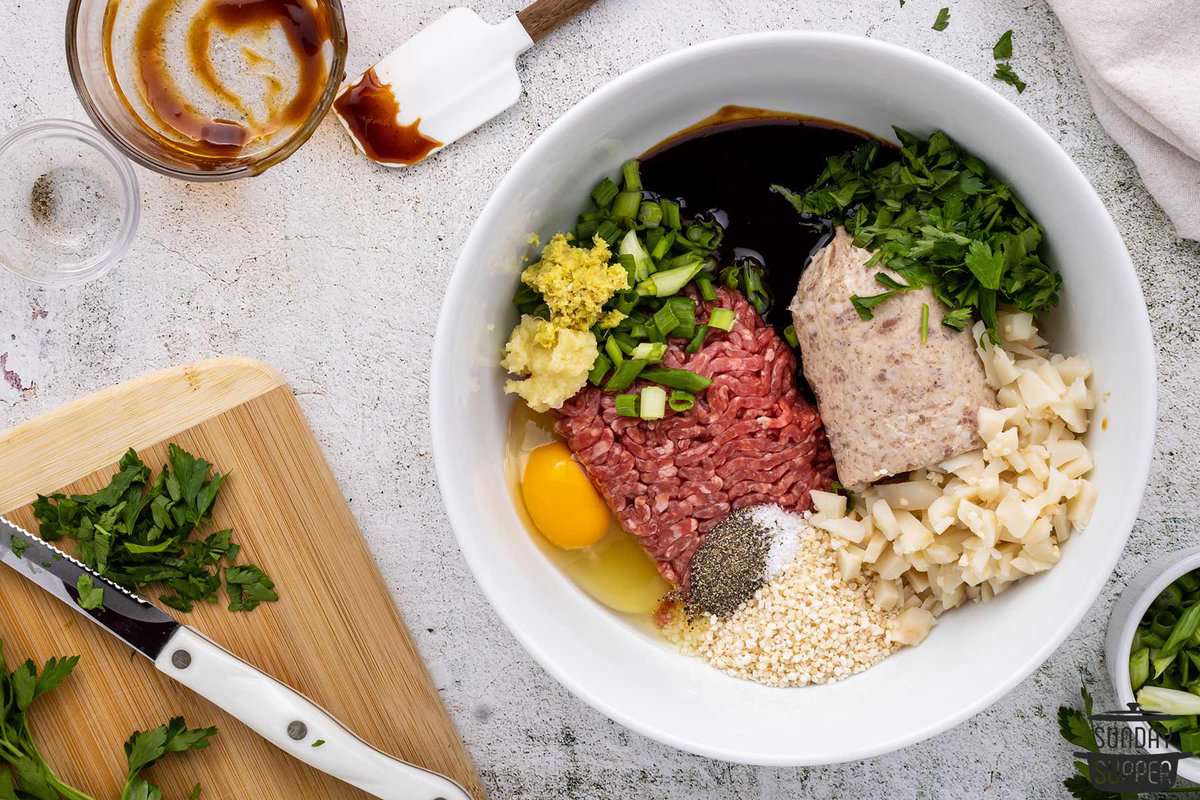 all the ingredients for asian meatballs added to a bowl to mix