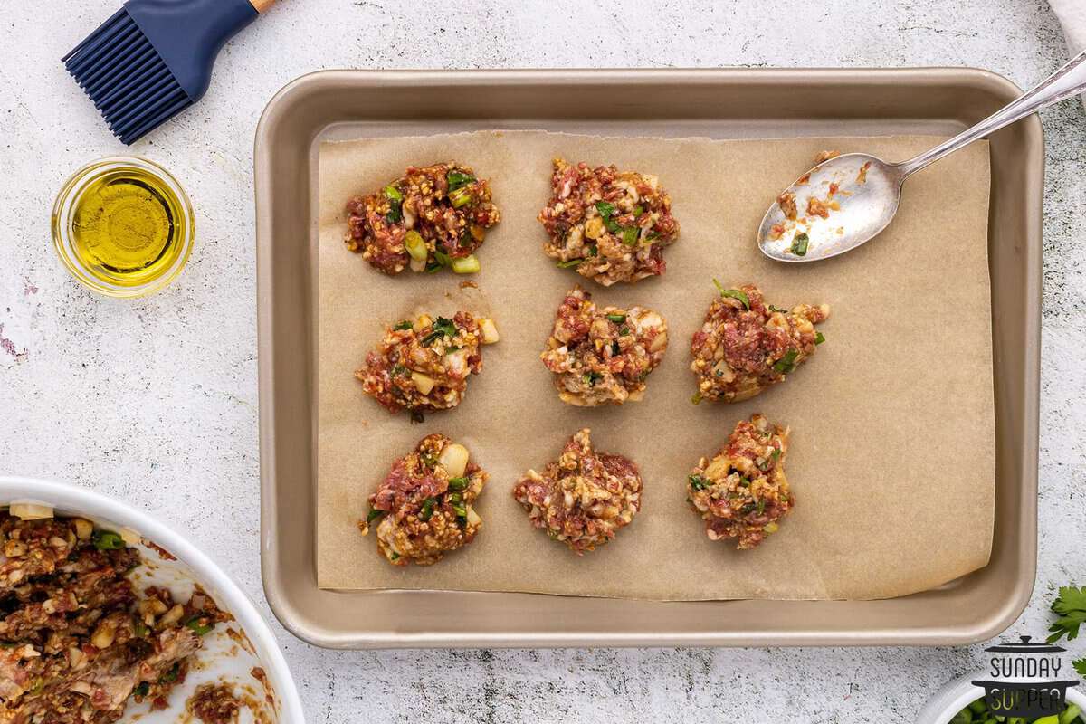 meatballs being portioned out on to a baking sheet