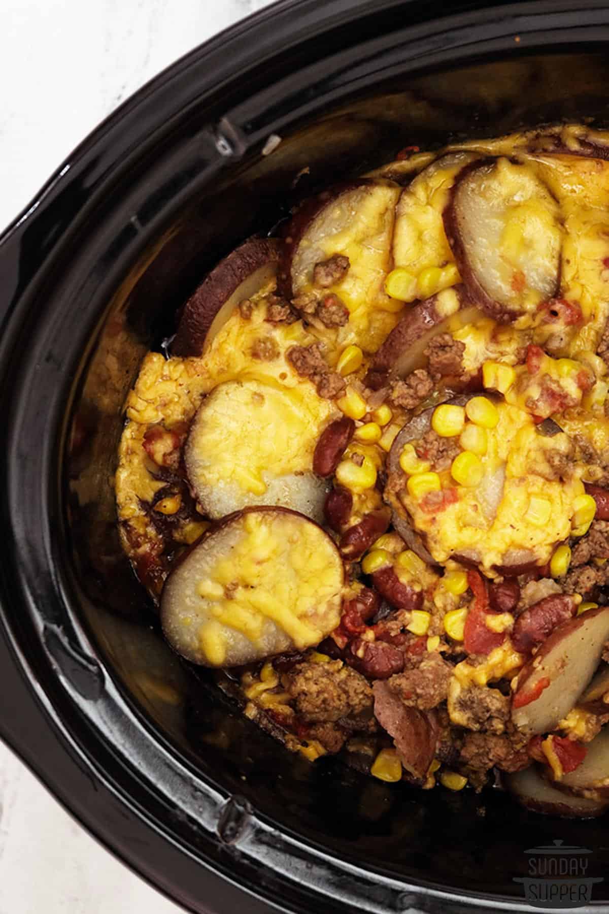 cooked cowboy casserole in the slow cooker with melted cheese