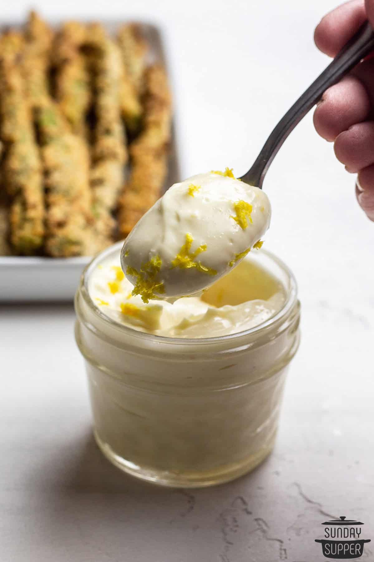 a jar of aioli with a spoon of it