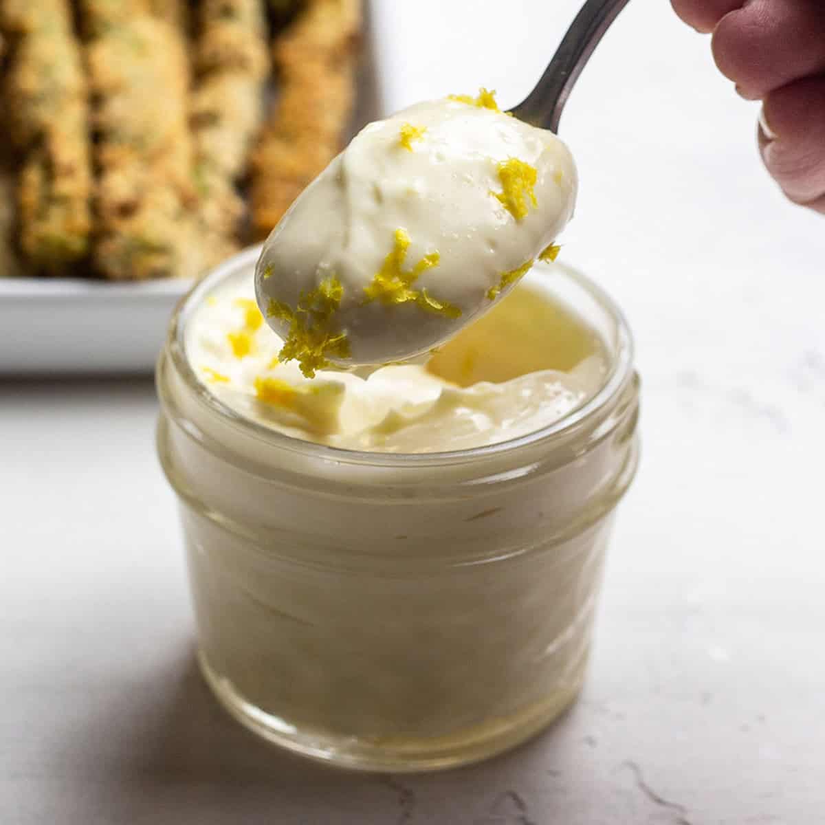 a spoonful of aioli with fresh lemon zest