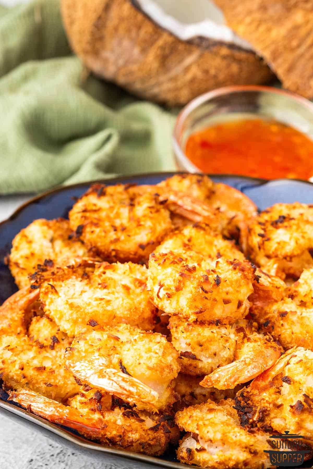 a serving plate stacked with air fryer coconut shrimp