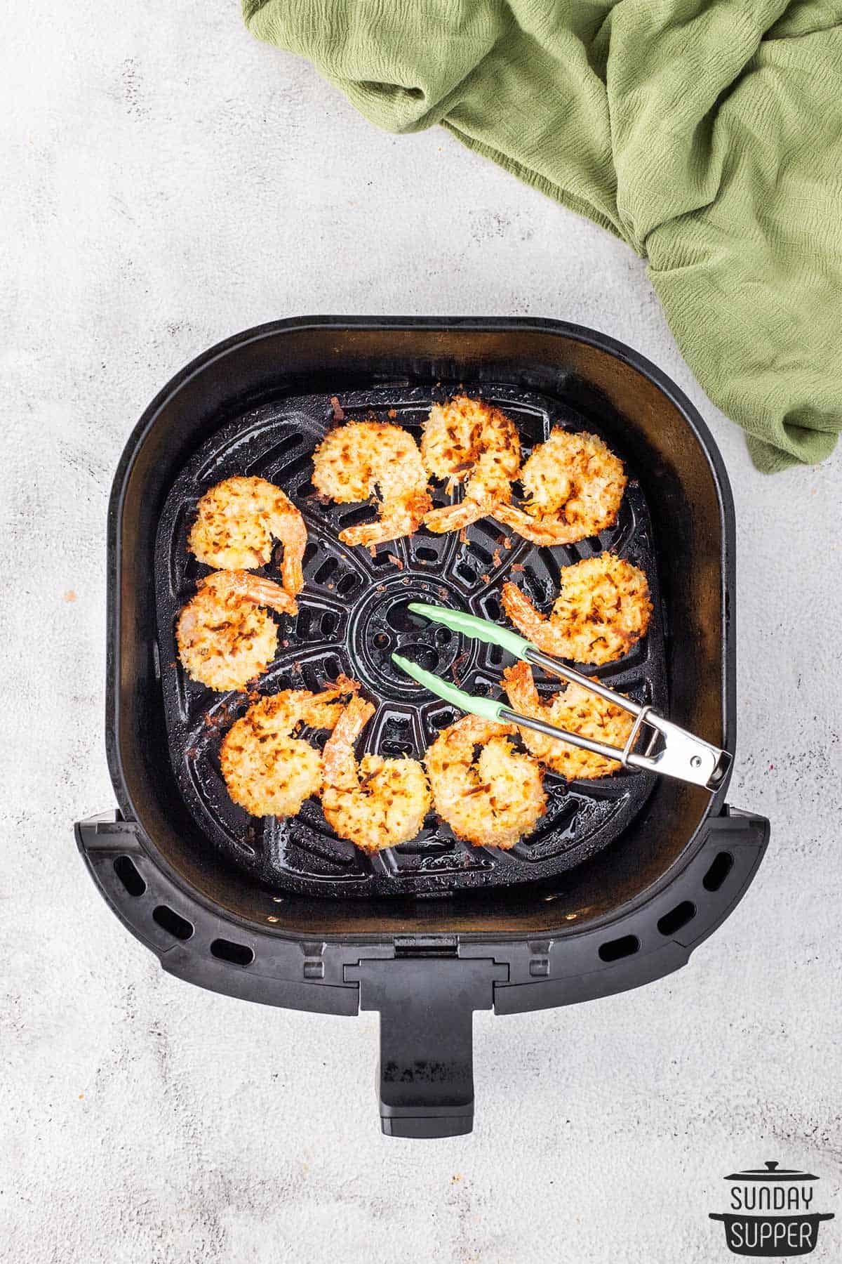 cooked shrimp being turned with tongs to complete cooking