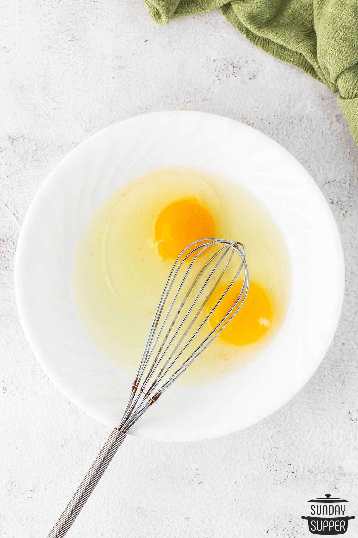 a bowl with two eggs to be whisked