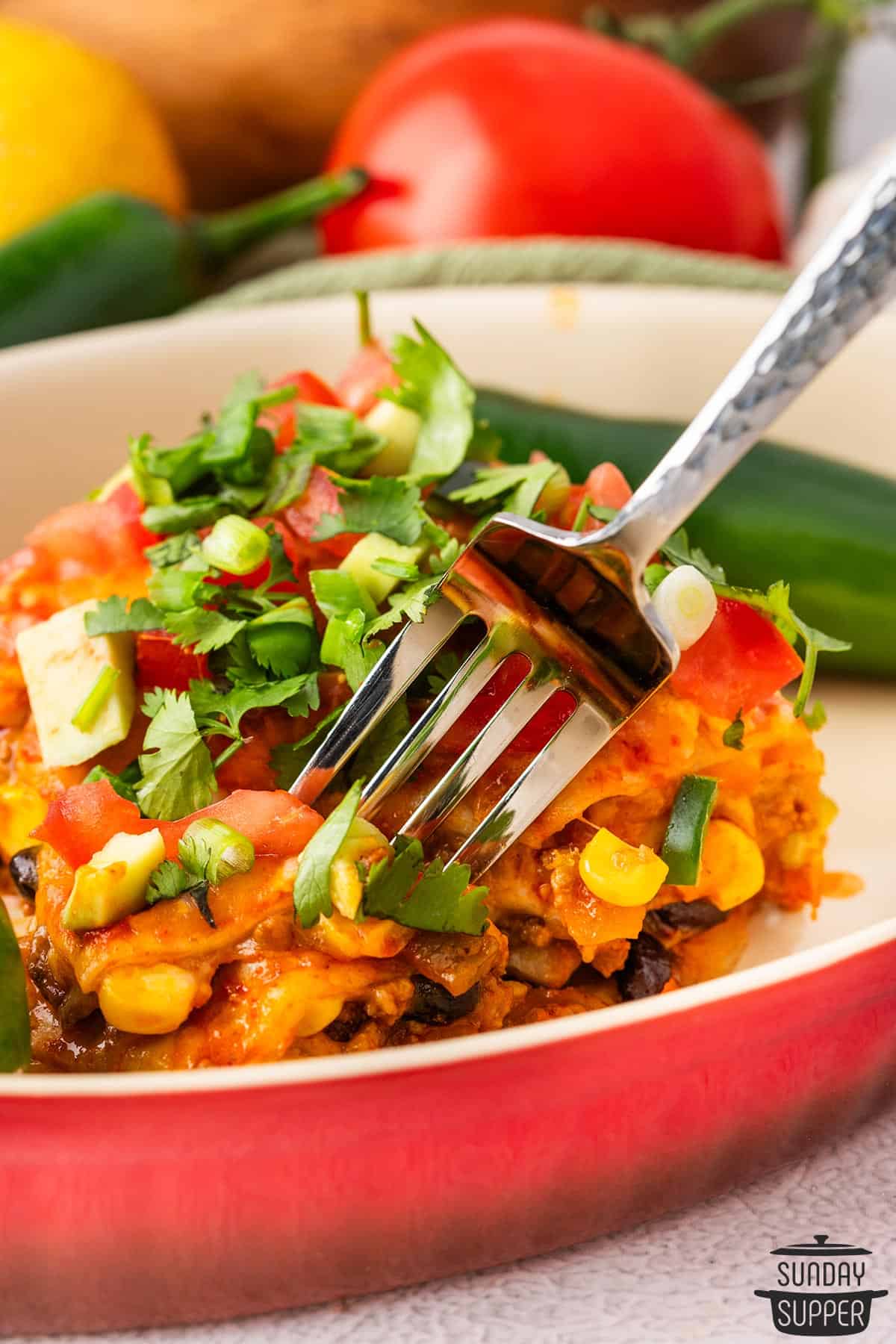 a fork taking a bite of beef enchilada casserole