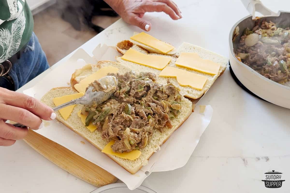 spreading steak mixture onto rolls