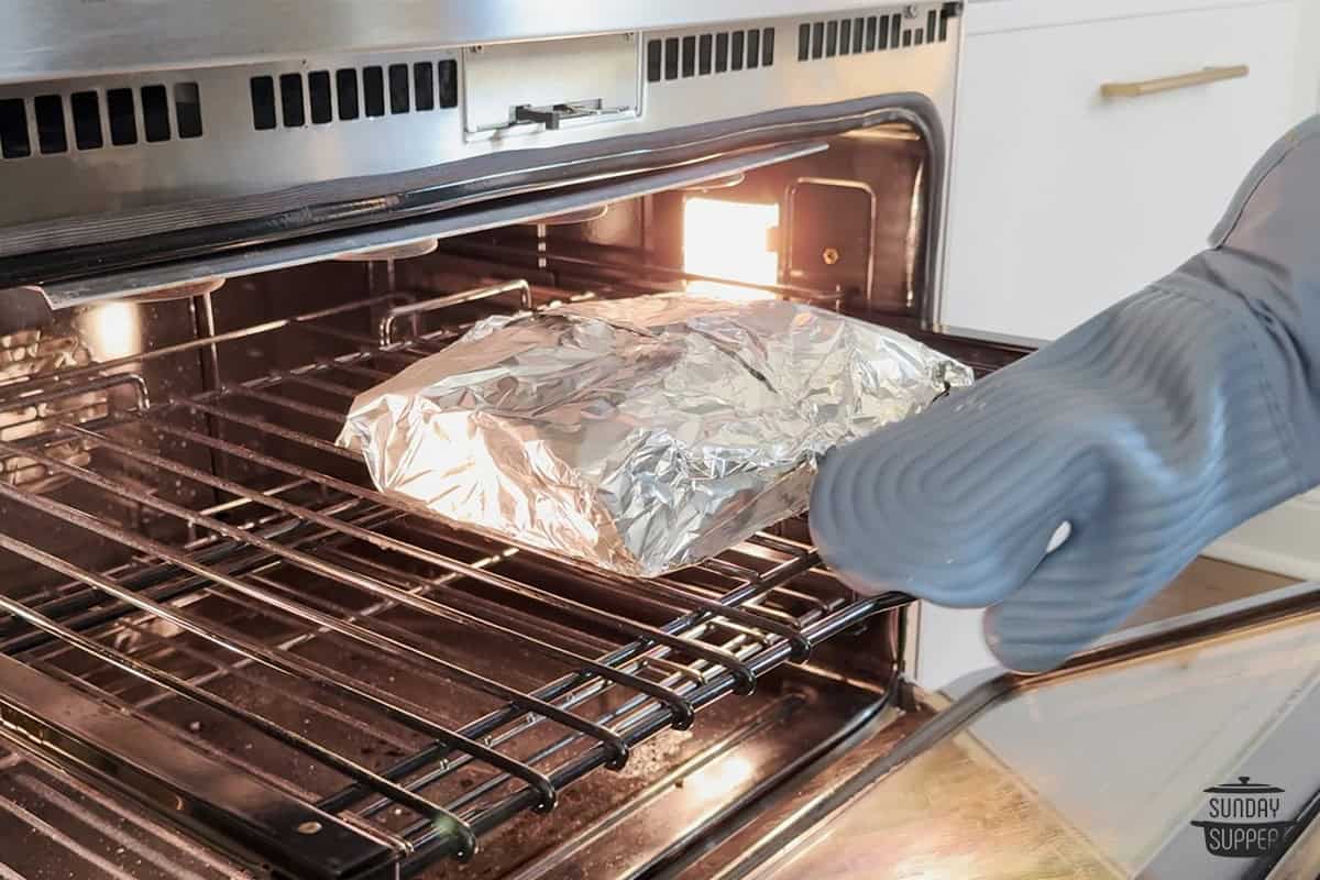 adding the foil wrapped rolls to the oven