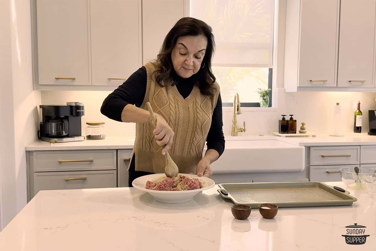 Isabel mixing the meat mixture for Italian wedding meatballs