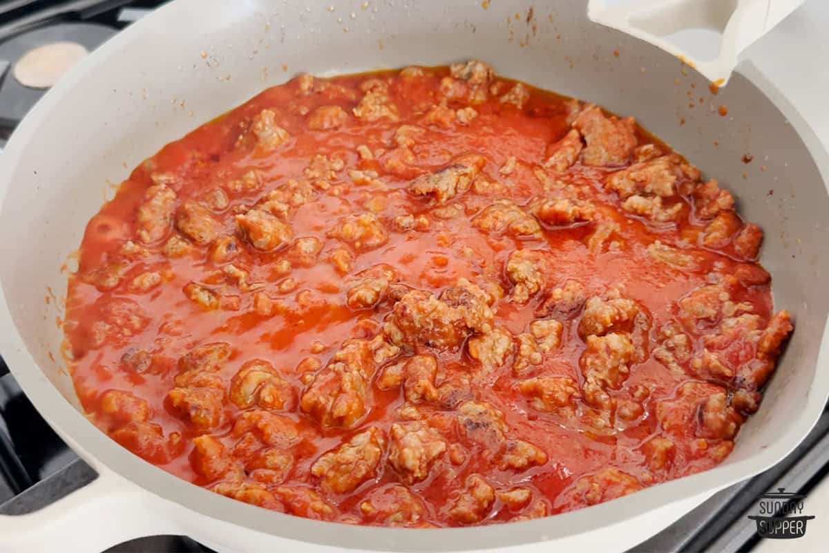 pink pasta sauce cooking in pan with sausage