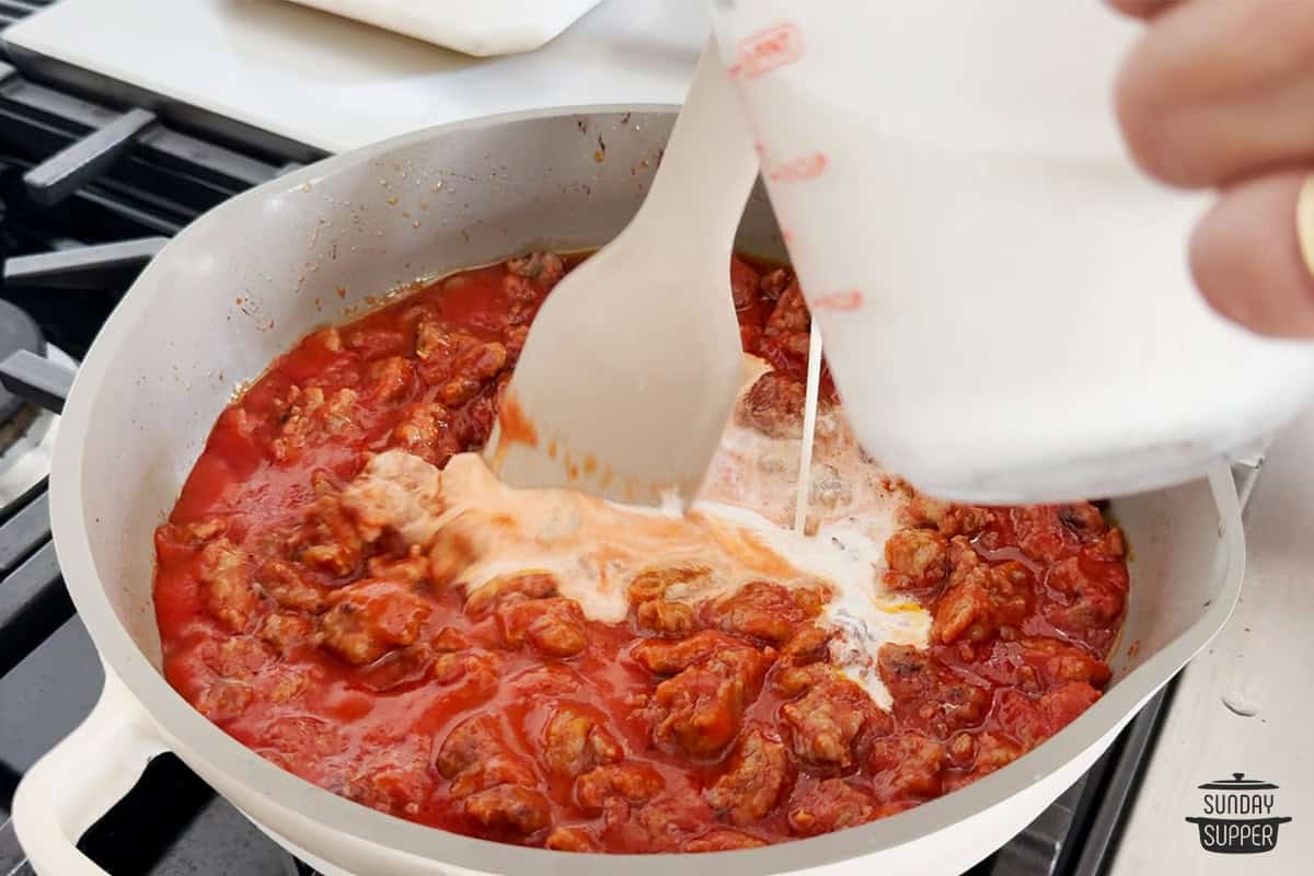 stirring milk into sauce