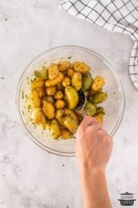 mixing potatoes with herbs and oil