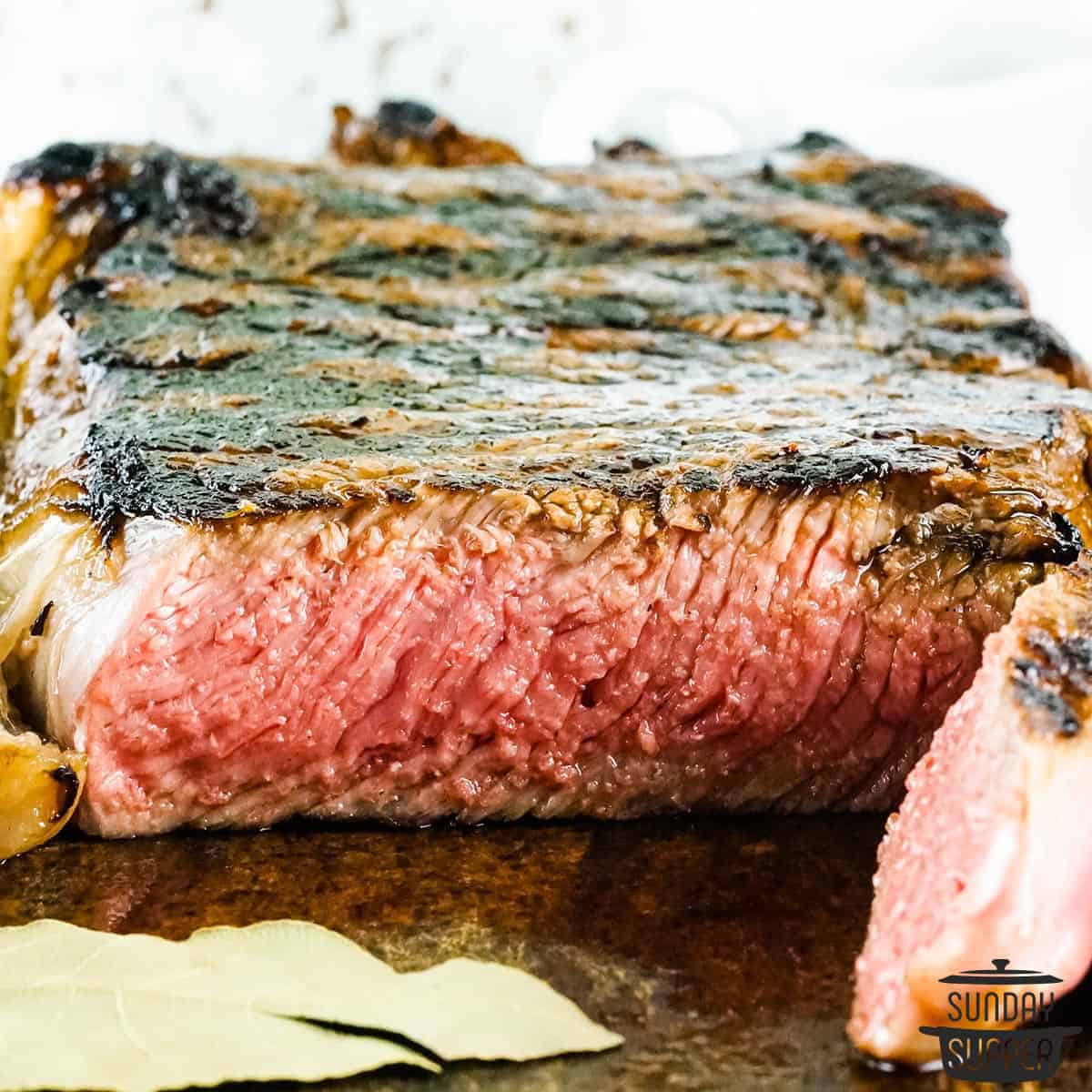 a grilled new york strip steak on a cutting board