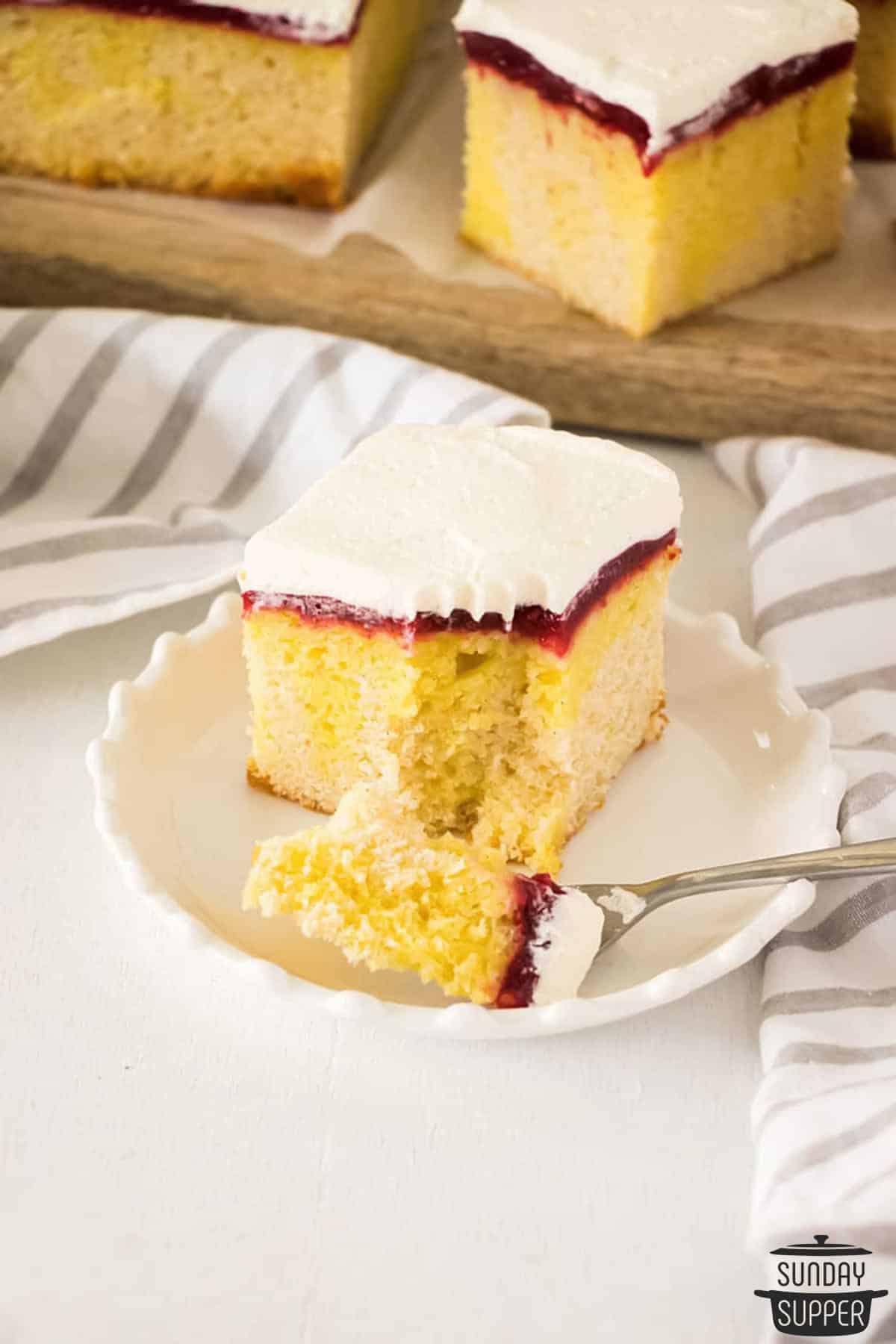 a slice of lemon poke cake with a fork