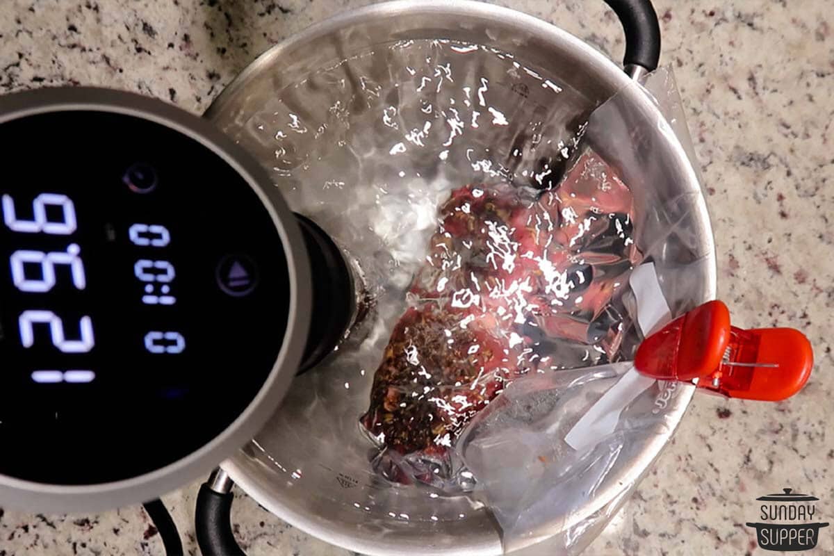 the bagged steaks placed in the sous vide water