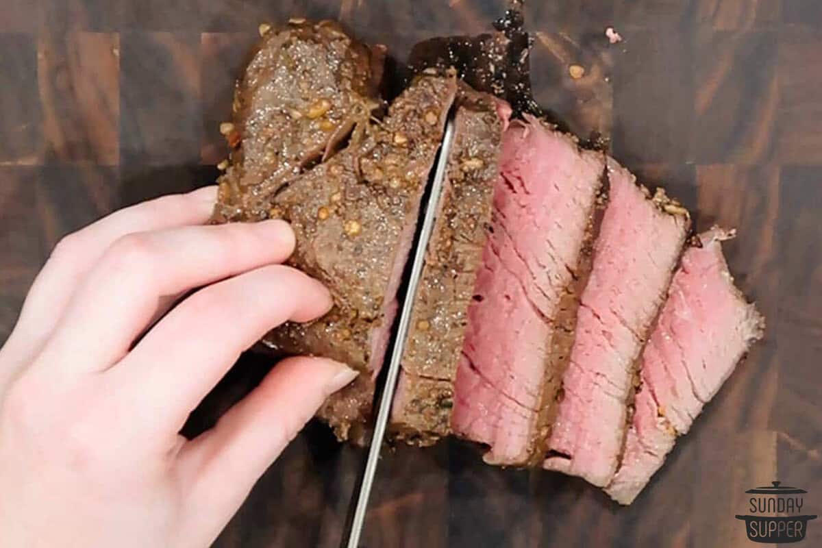 slicing the filet mignon on a cutting board