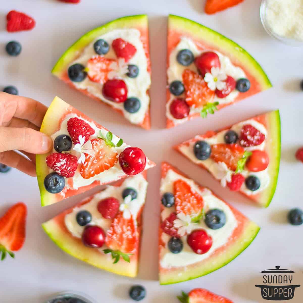 picking up a slice of watermelon pizza