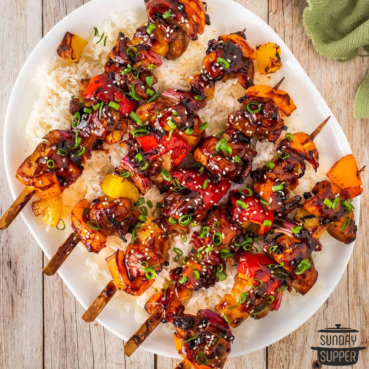 a plate of teriyaki chicken skewers