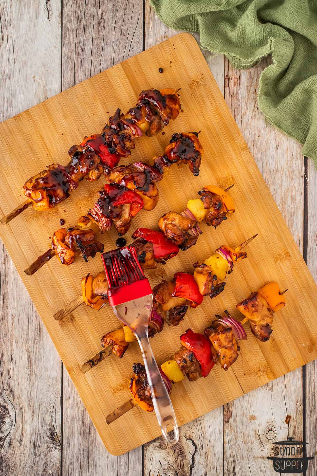 brushing glaze onto the skewers