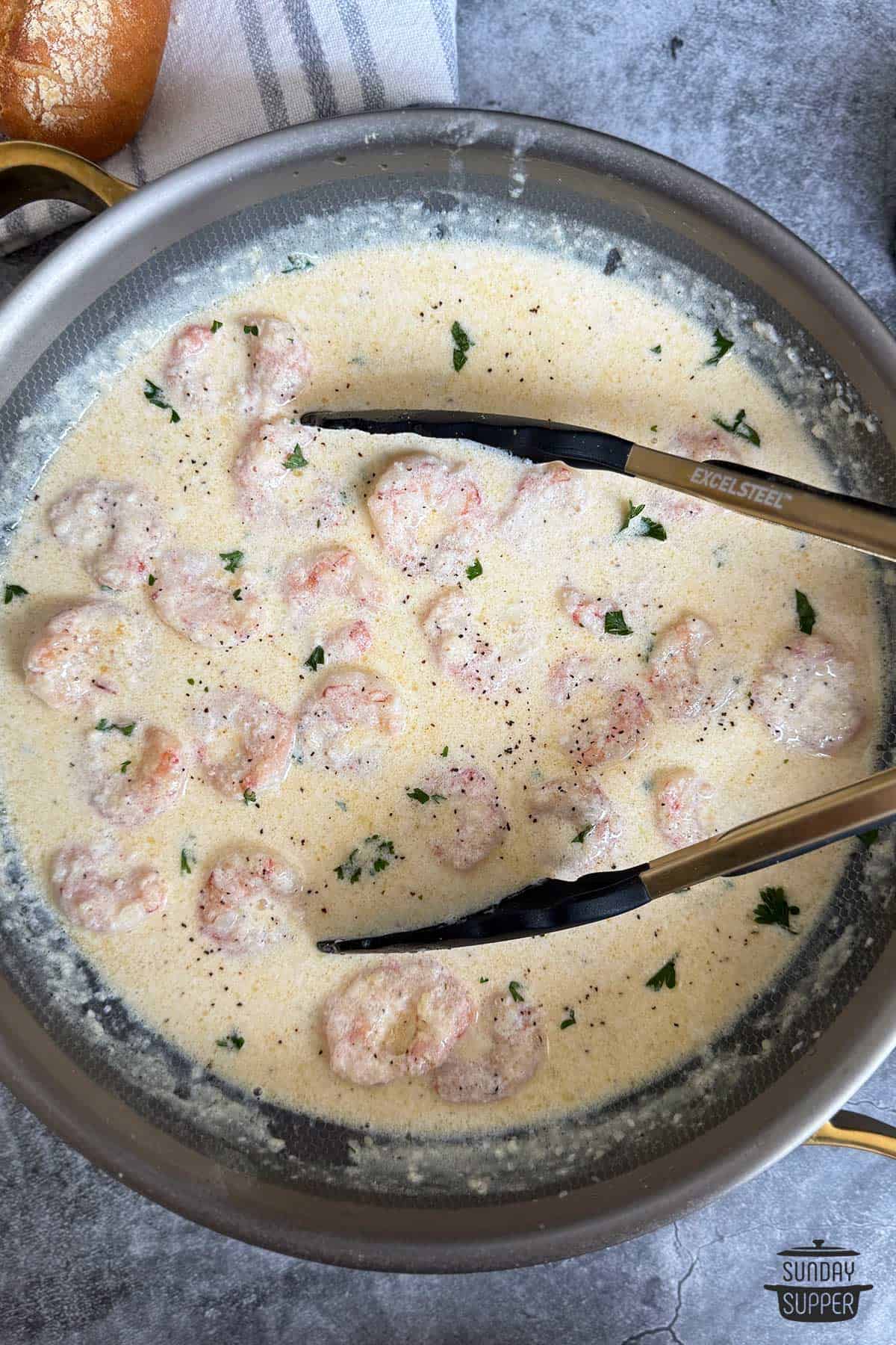 creamy shrimp cooking in a stainless steel pan ready to serve