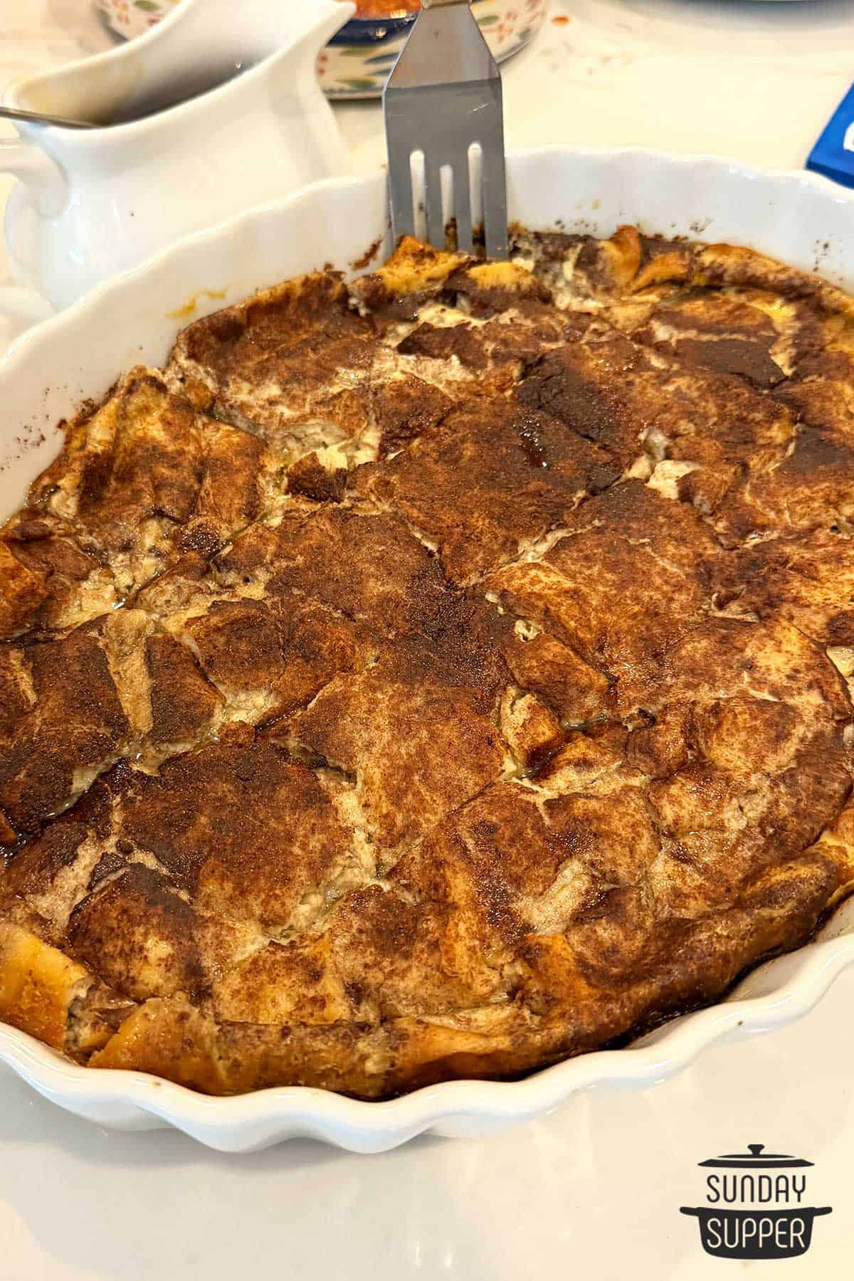 french toast casserole in a white baking dish cut into pieces